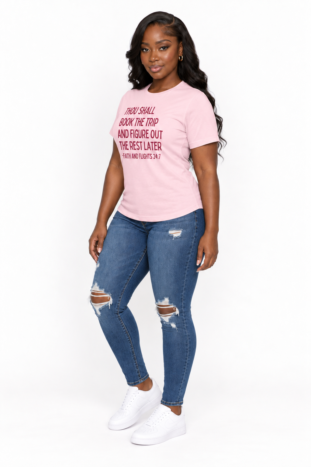 AI styling mockup: Khadijah in soft pink Faith and Flights burgundy-print tee with distressed jeans, angled view